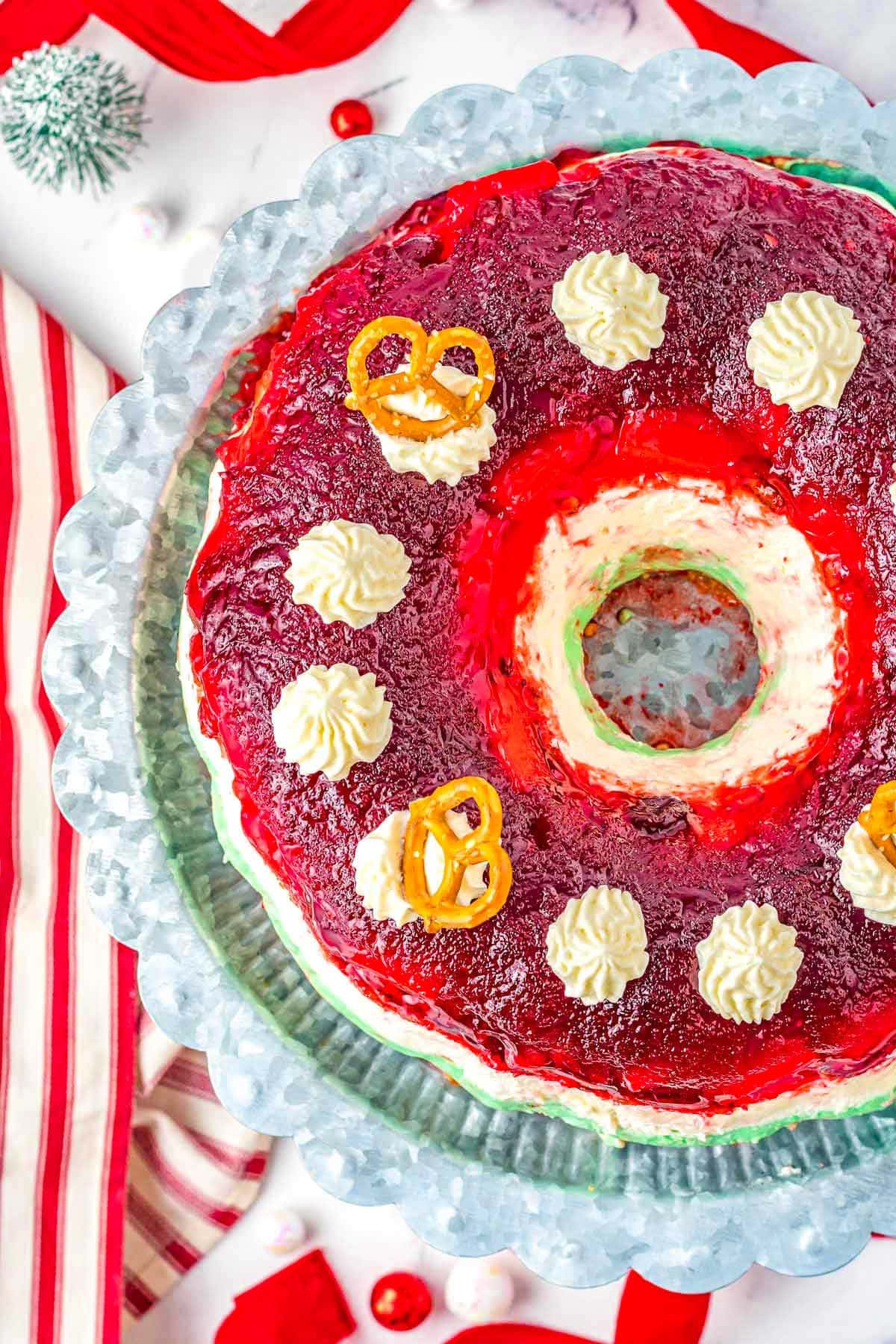 top down look at three layered cranberry dessert salad with red white and green layers on a wood pedestal.