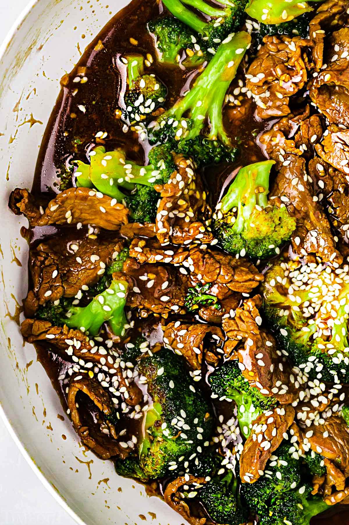 top down look at beef and broccoli stir fry in a white skillet.