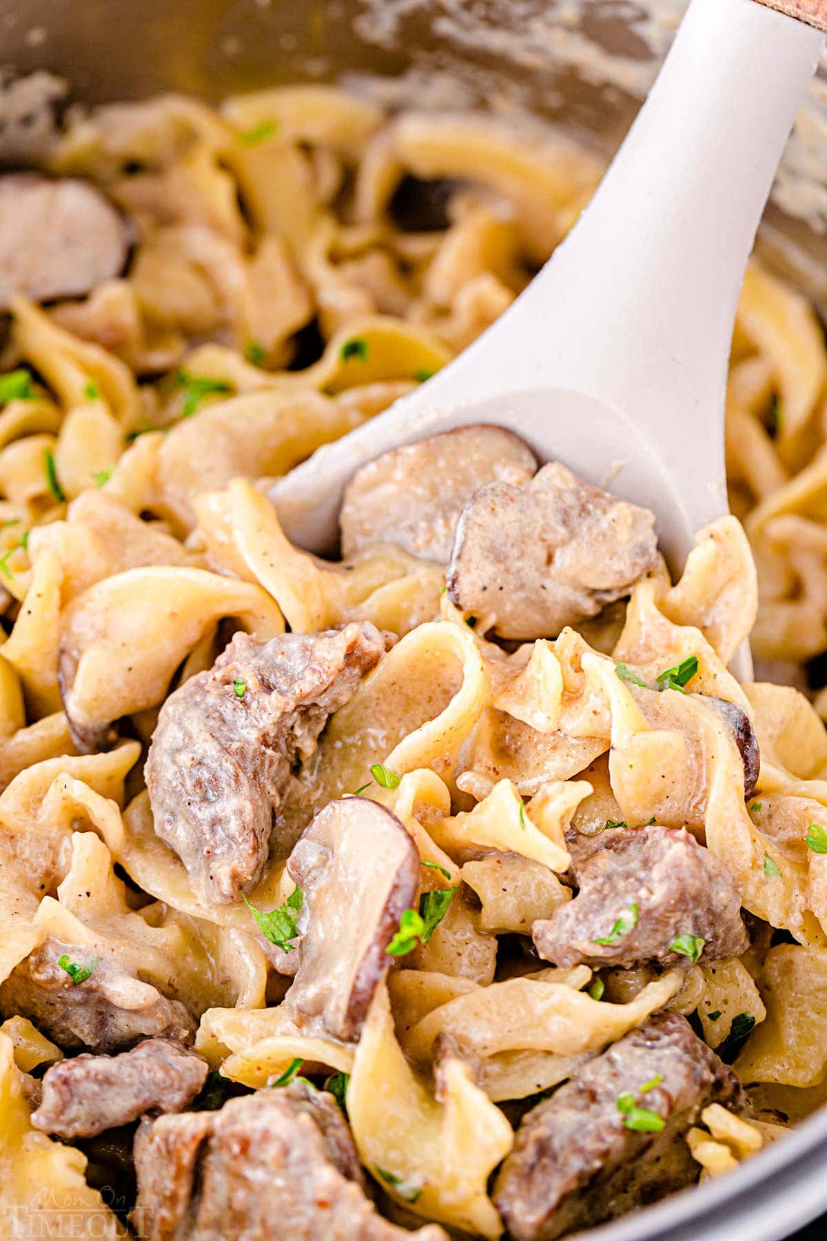 close up look of spoonful of beef stroganoff still in the instant pot.