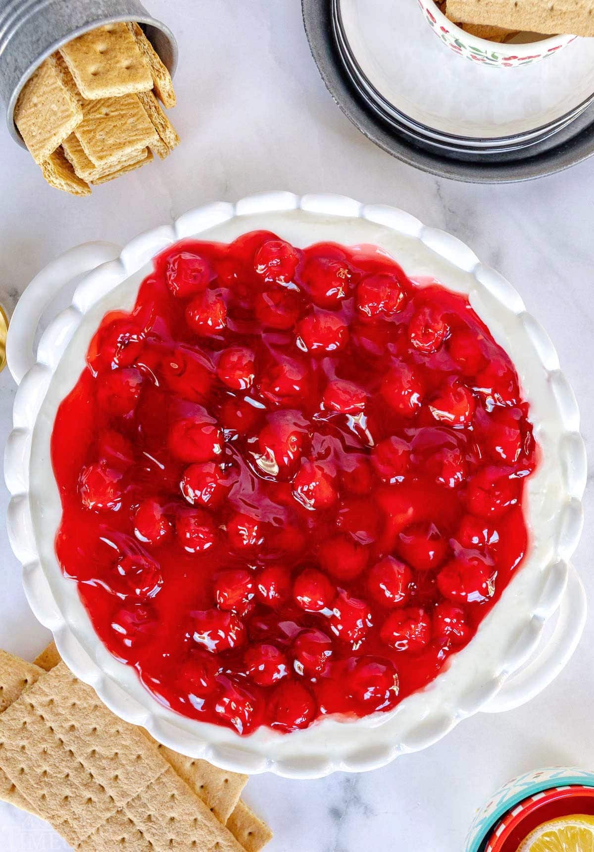 top down look at cherry cheesecake dip in a ceramic white pie plate with graham crackers around the dish for dipping.