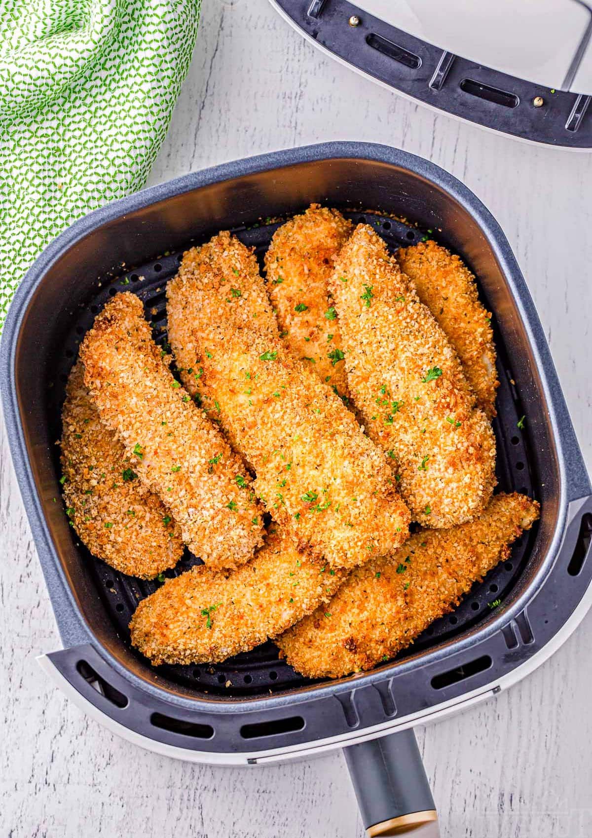 top down look at air fryer chicken tenders in an air fryer basket.