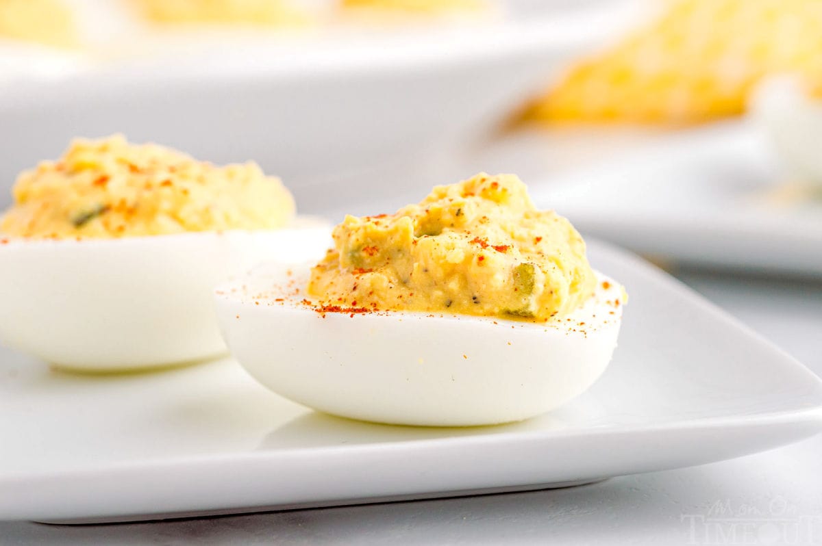 side profile of two deviled eggs on a white plate.