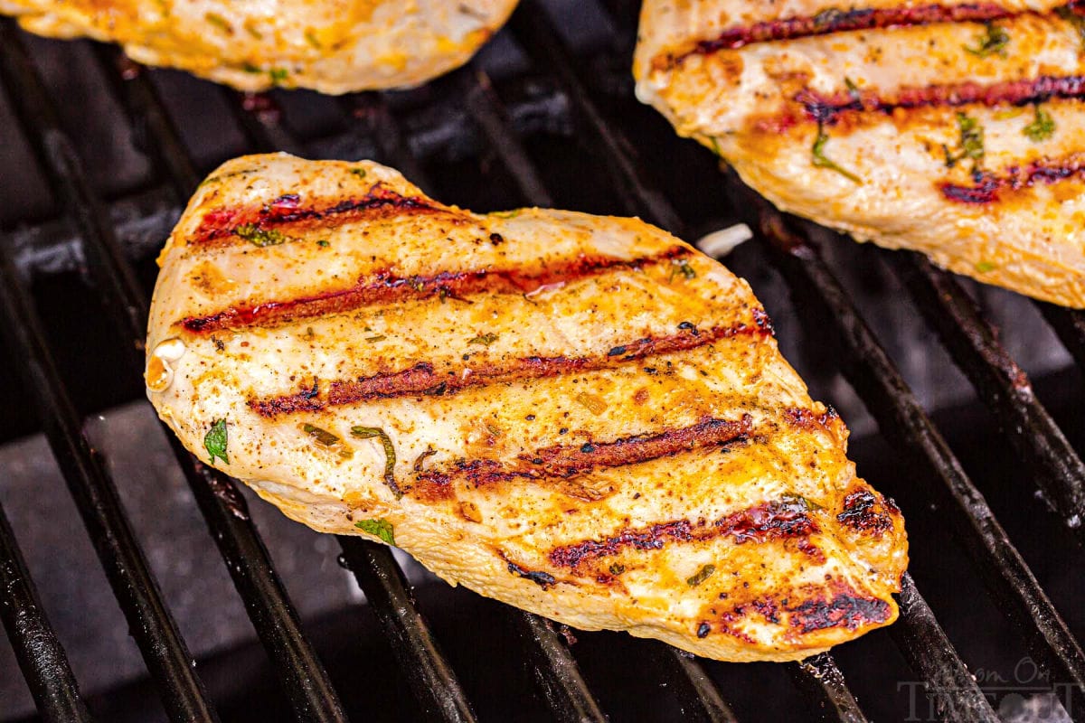 chicken breast being grilled with nice sear marks shown.
