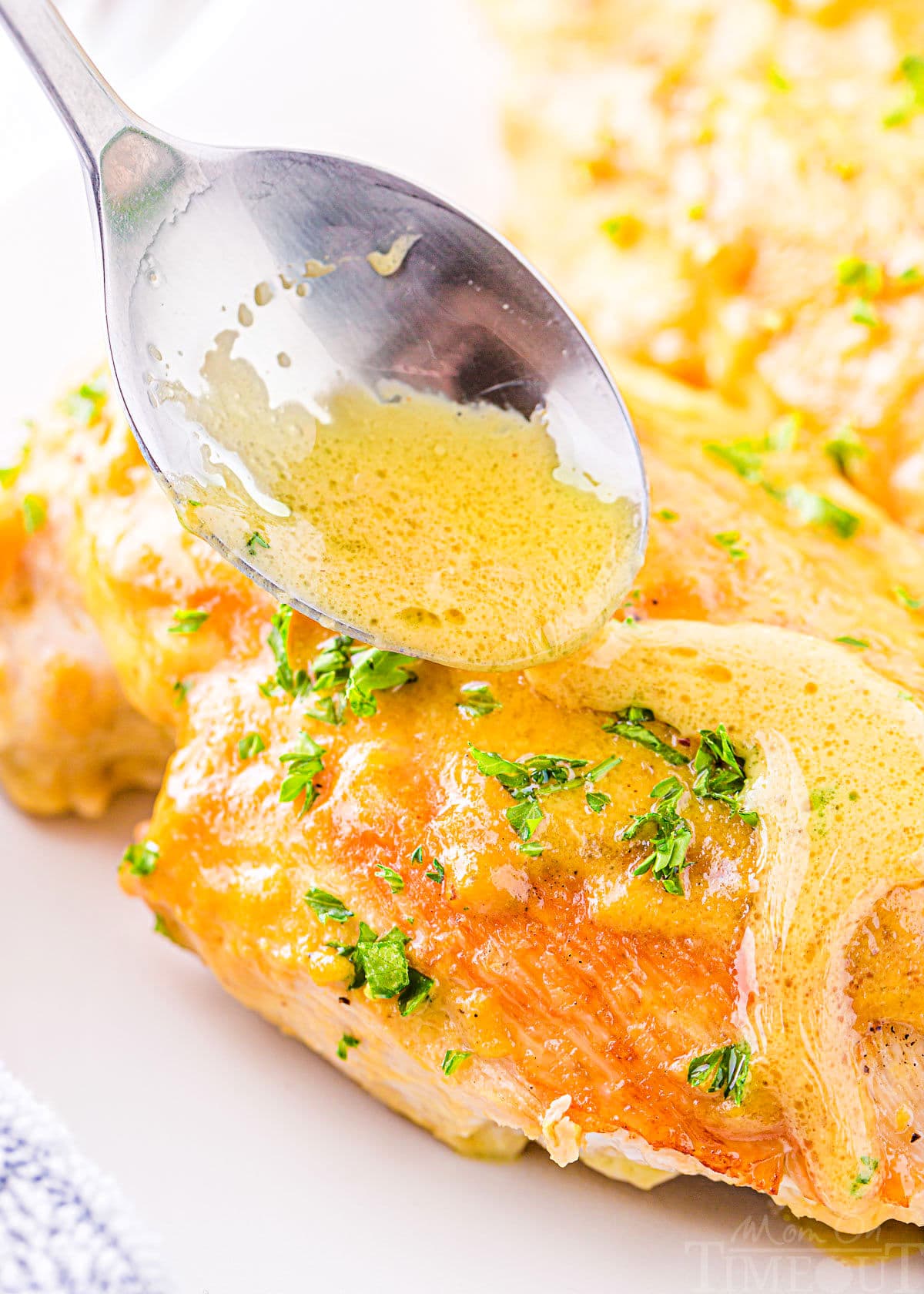 honey mustard sauce being drizzled on baked chicken breast.