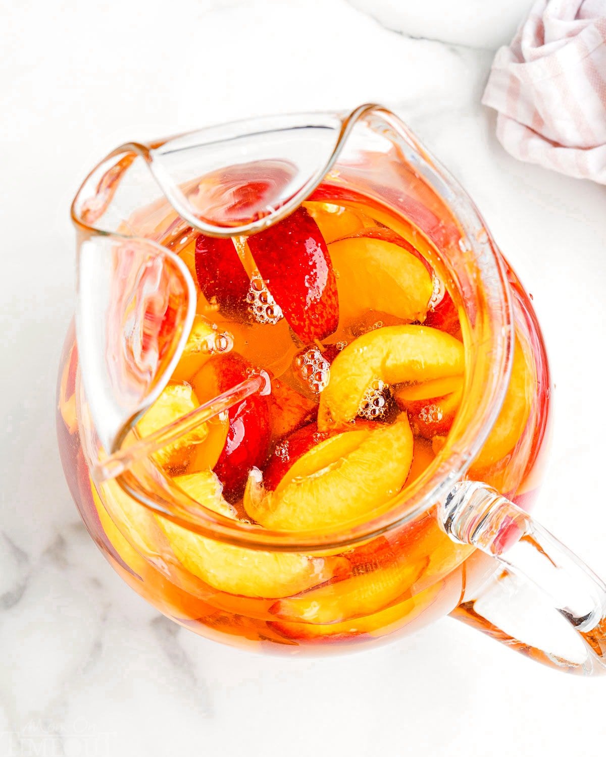 pitcher of white sangria flavored with peaches and peach liquor. 