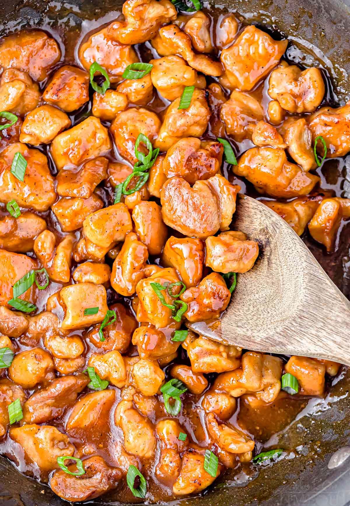 top down look at honey chicken in large black skillet cooked through and ready to be served with rice or steamed veggies.