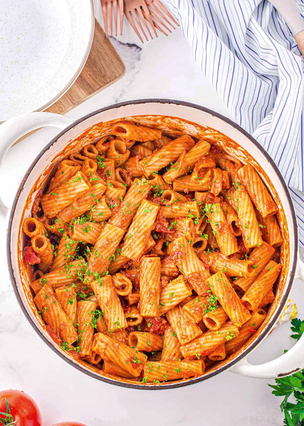 top down look at one pot pasta in a white dutch oven garnished with fresh parsley.