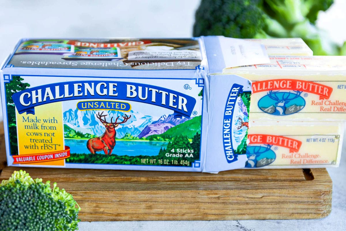 box of challenge unsalted butter on small cutting board with butter sticks pulled out of the side of the box.