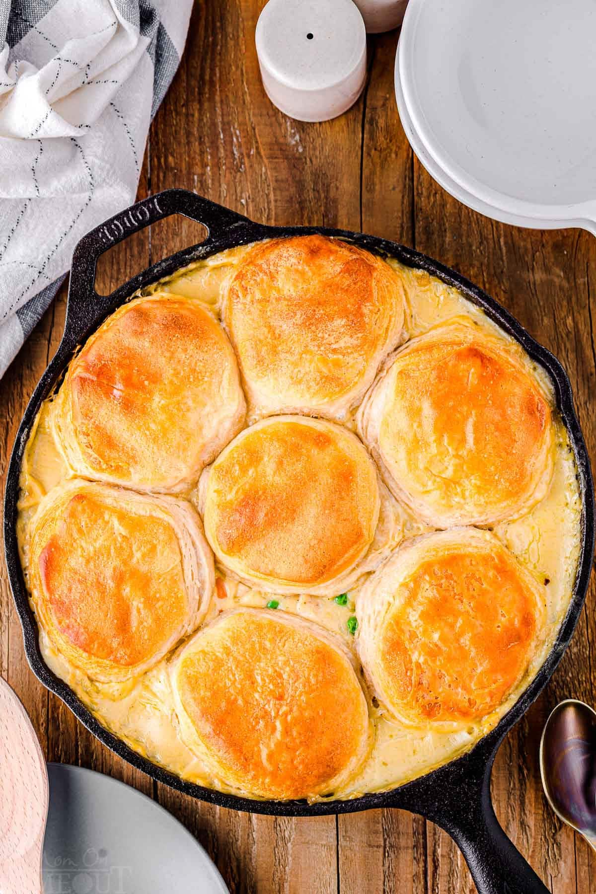 top down look at black cast iron skillet with turkey pot pie in it. skillet is sitting on a wood surface.