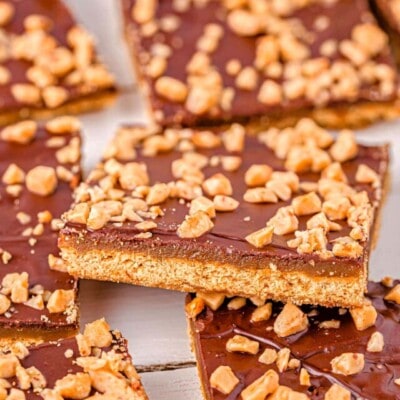 graham cracker toffee laid out on parchment with one square sitting up at an angle.