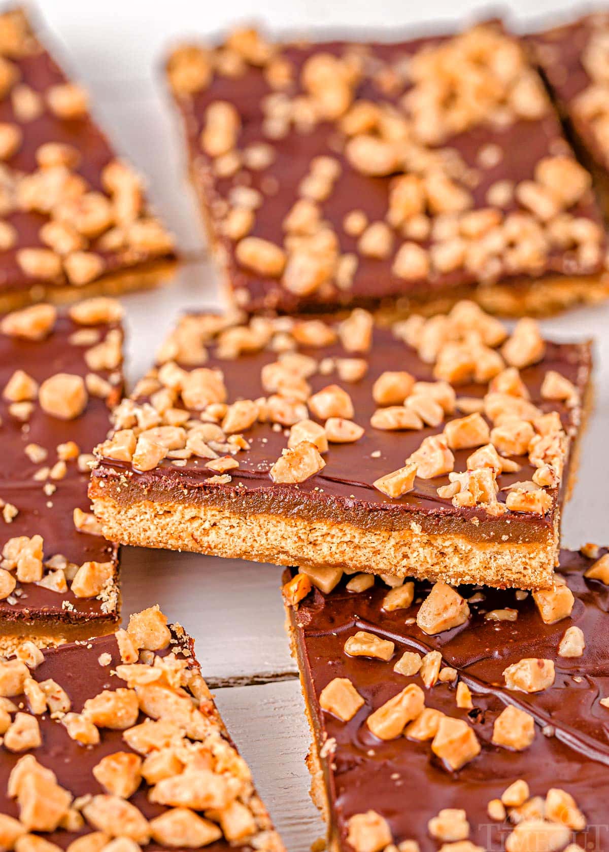 graham cracker toffee laid out on parchment with one square sitting up at an angle.