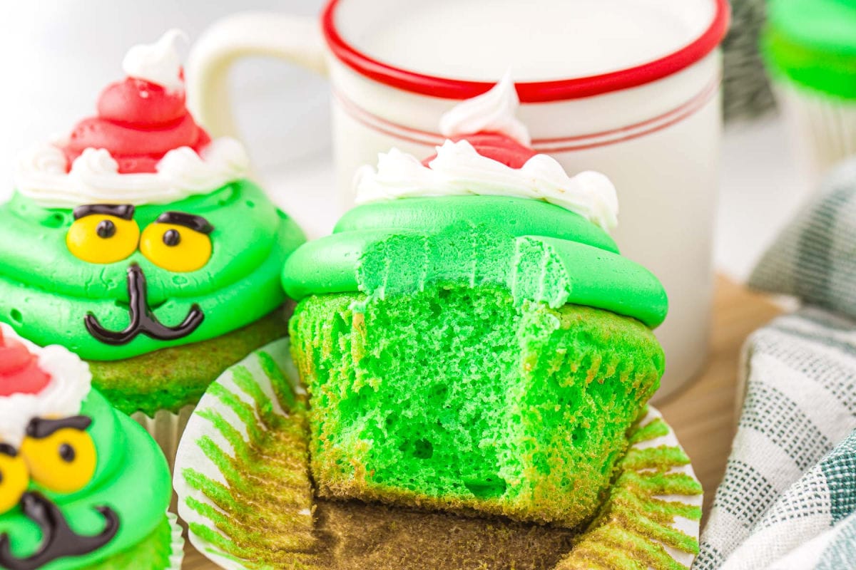 green cupcakes with green frosting decorated to look like the grin with the main cupcake with a bit taken out of it.