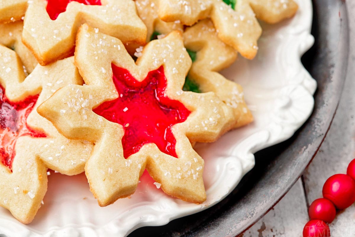 close up of stained glass cookie with red center sitting on a white plate.