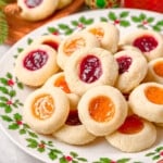 christmas plate piled high with thumbprint cookies filled with apricot and raspberry jam.