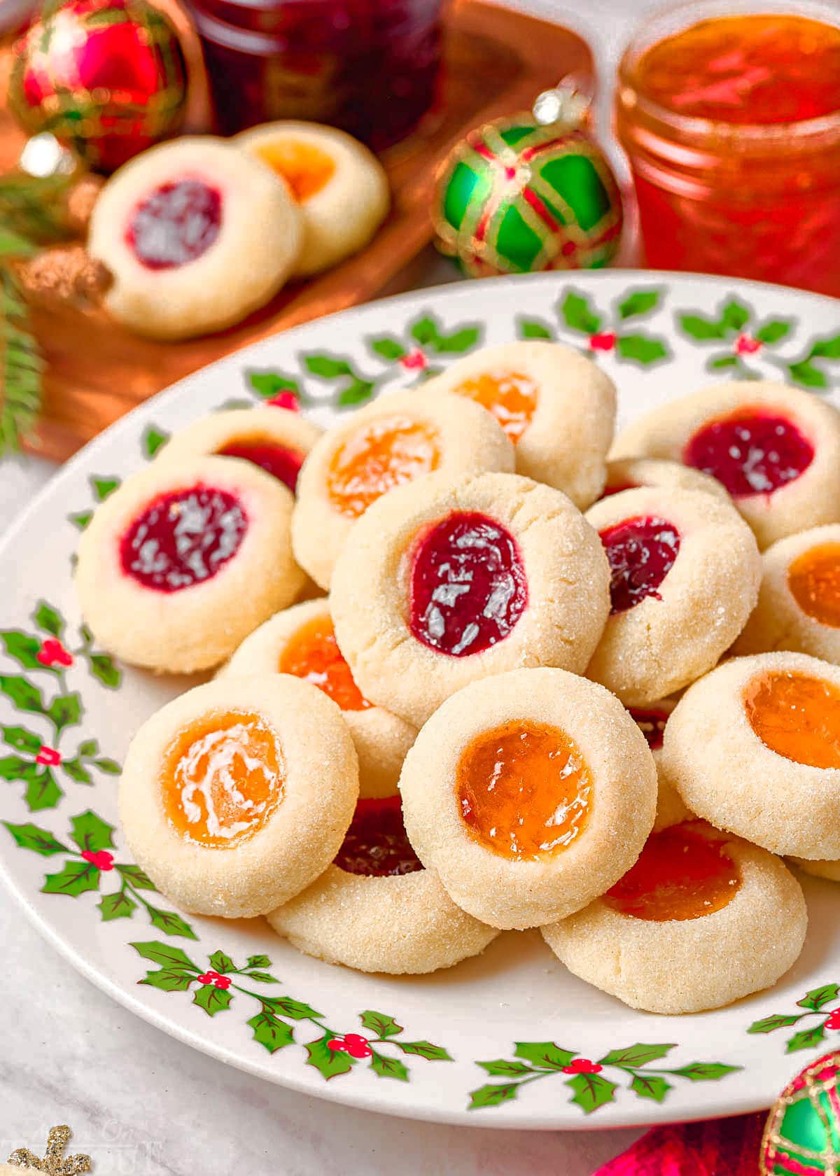 christmas plate piled high with thumbprint cookies filled with apricot and raspberry jam.