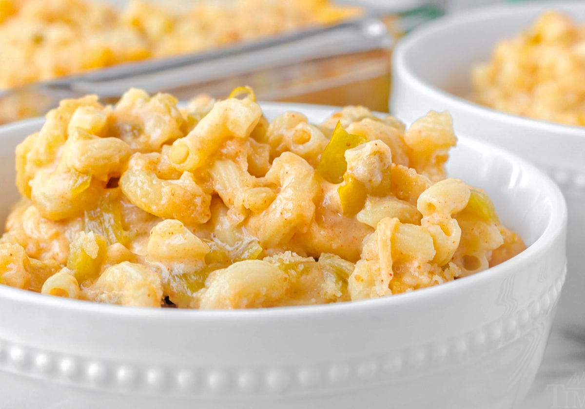 close up look at green chile mac and cheese in a white bowl.