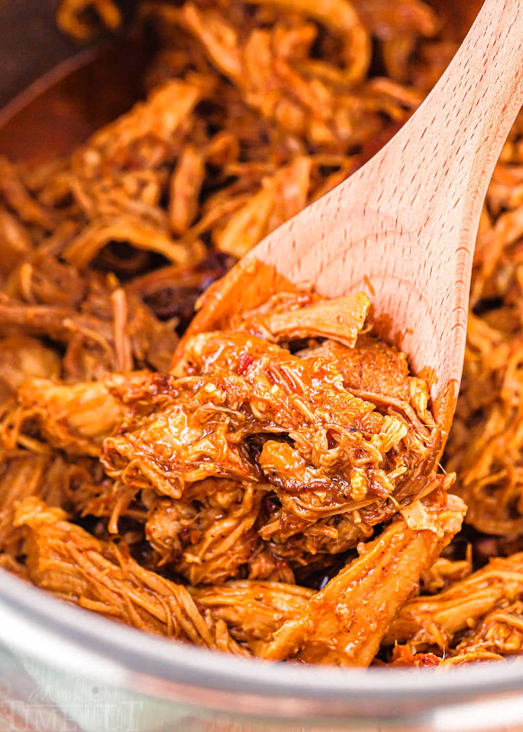 pulled pork in instant pot with wooden spoon. meat is already shredded.