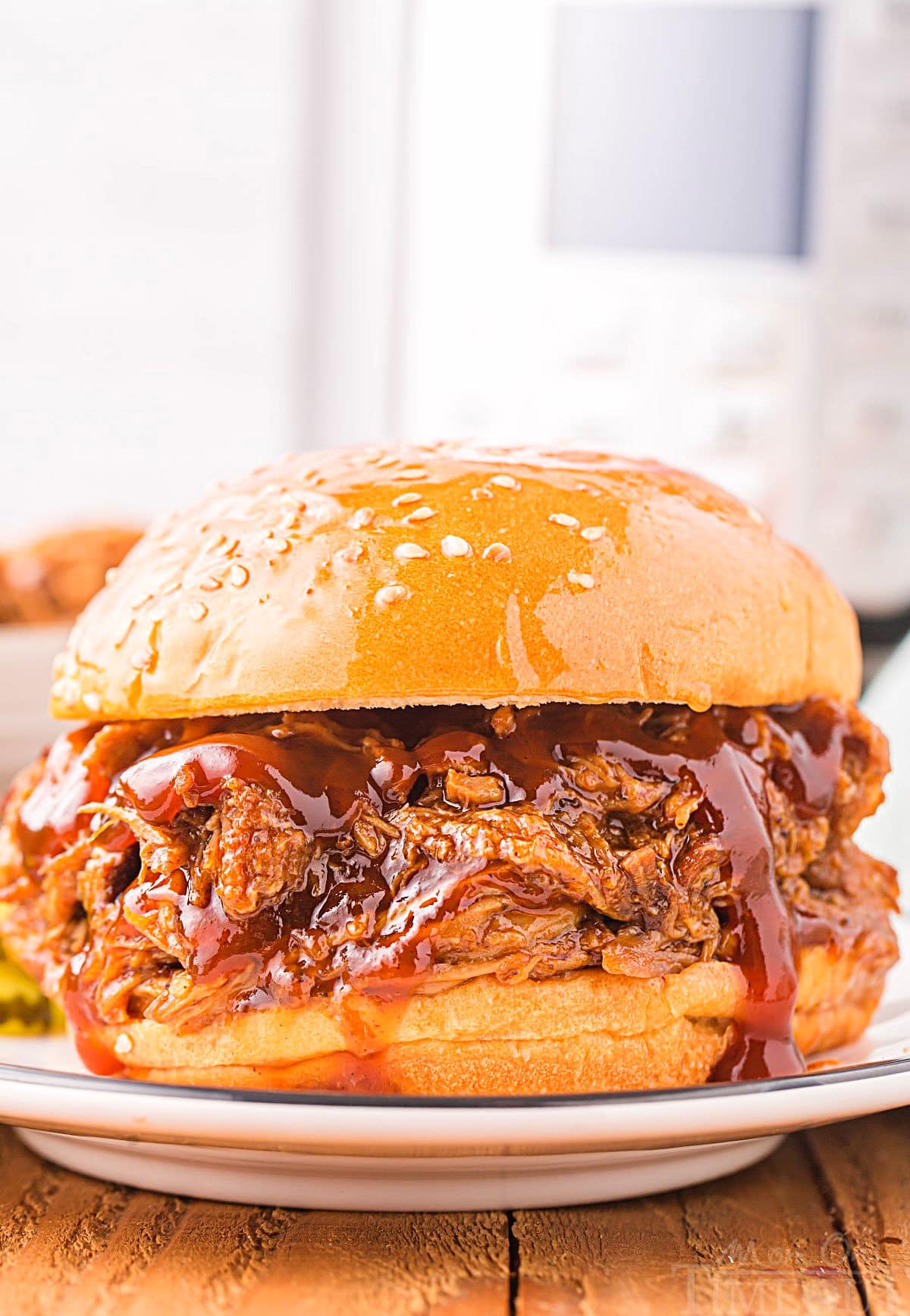 pulled pork sandwich sitting on plate in front of an instant pot.