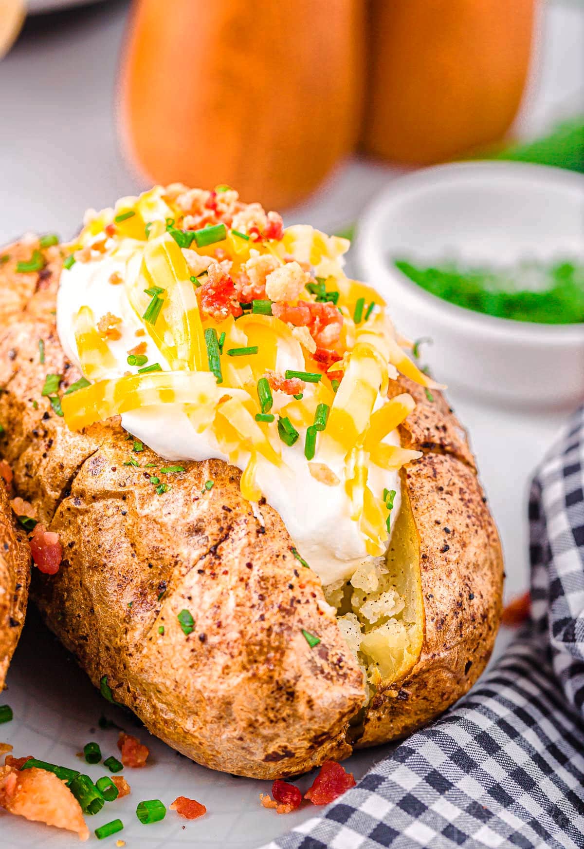 full loaded air fryer baked potato topped with sour cream, cheese, bacon and chives.