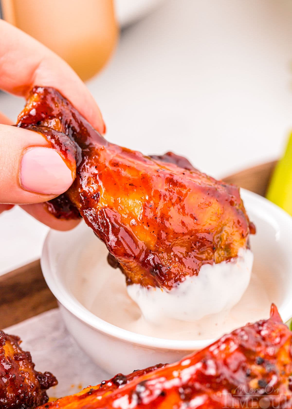 bbq air fryer chicken wing being dipped in ranch.