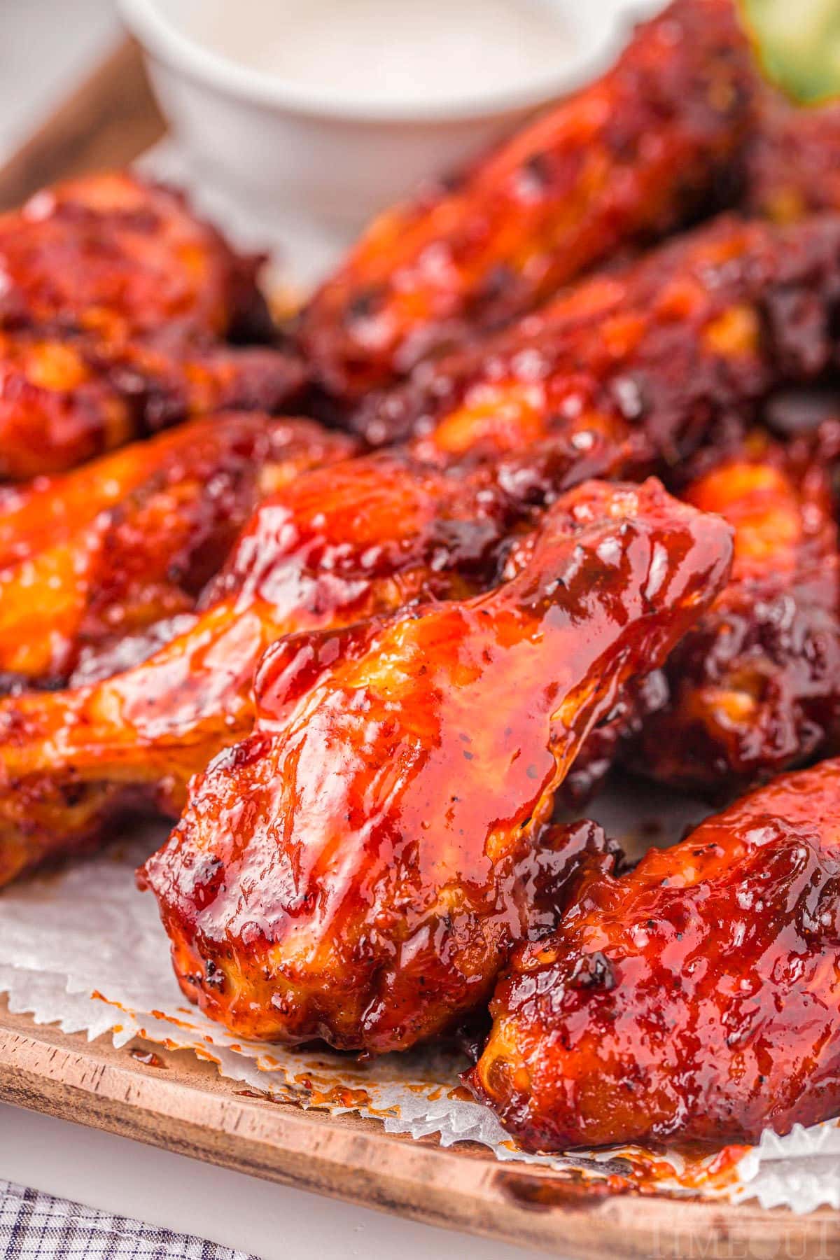 chicken wings made in the air fryer are brushed with bbq sauce and ready to serve on a wooden board.