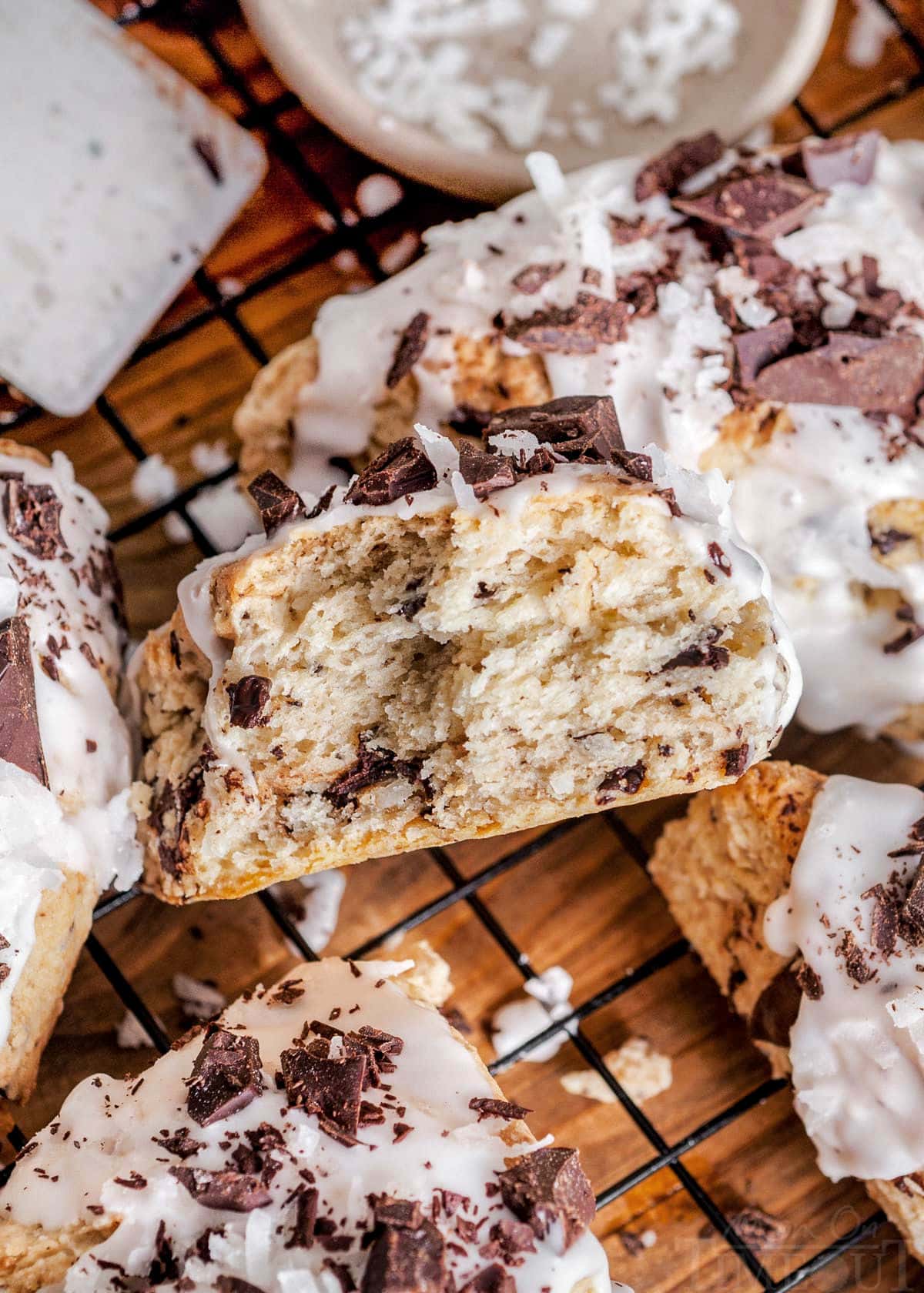 coconut scone broken in half and placed next to more scones on a cooling rack.