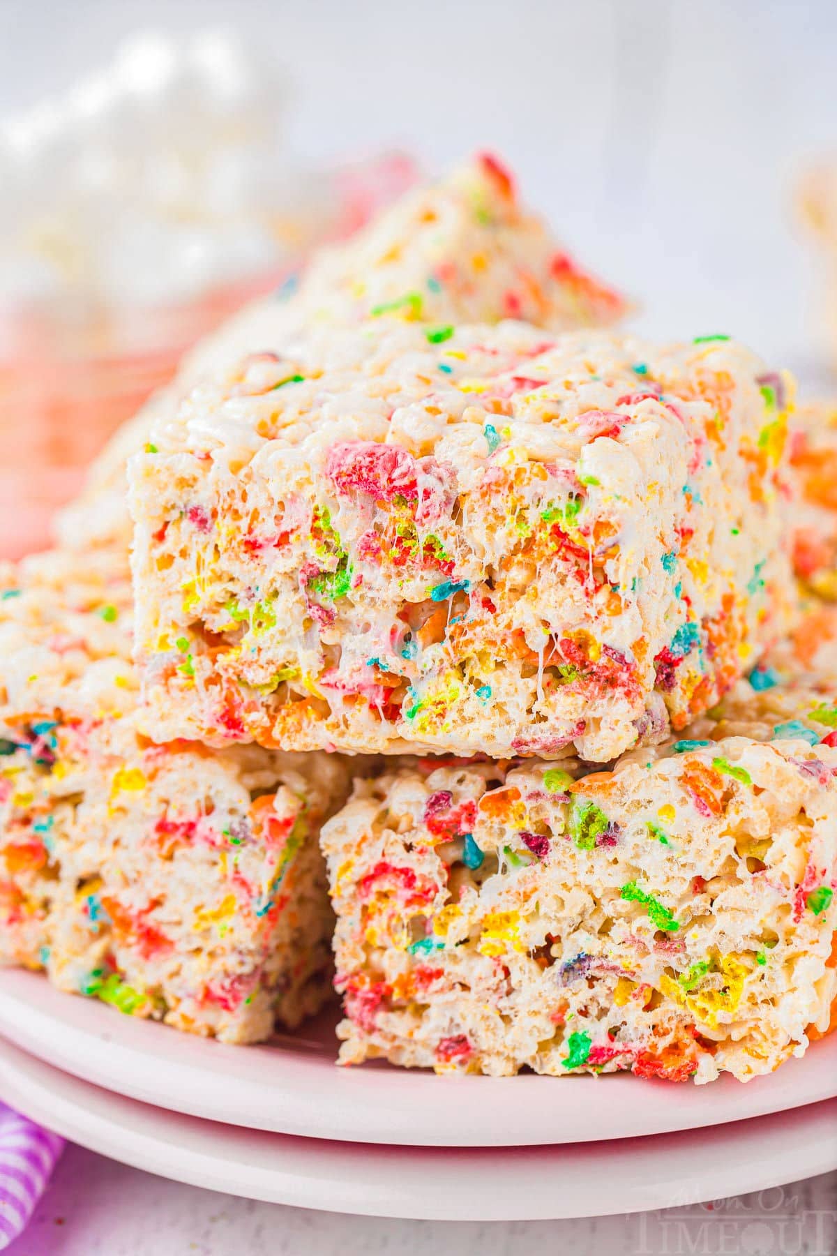 rice krispie treats stacked on light pink plates.