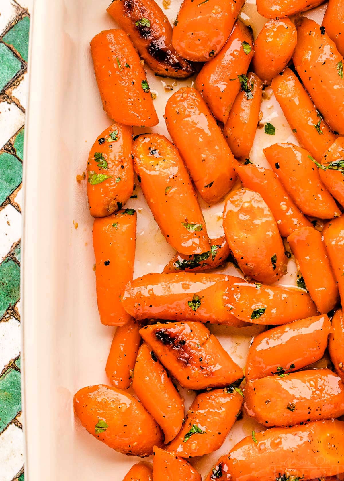 top down look at honey roasted carrots in white baking dish.