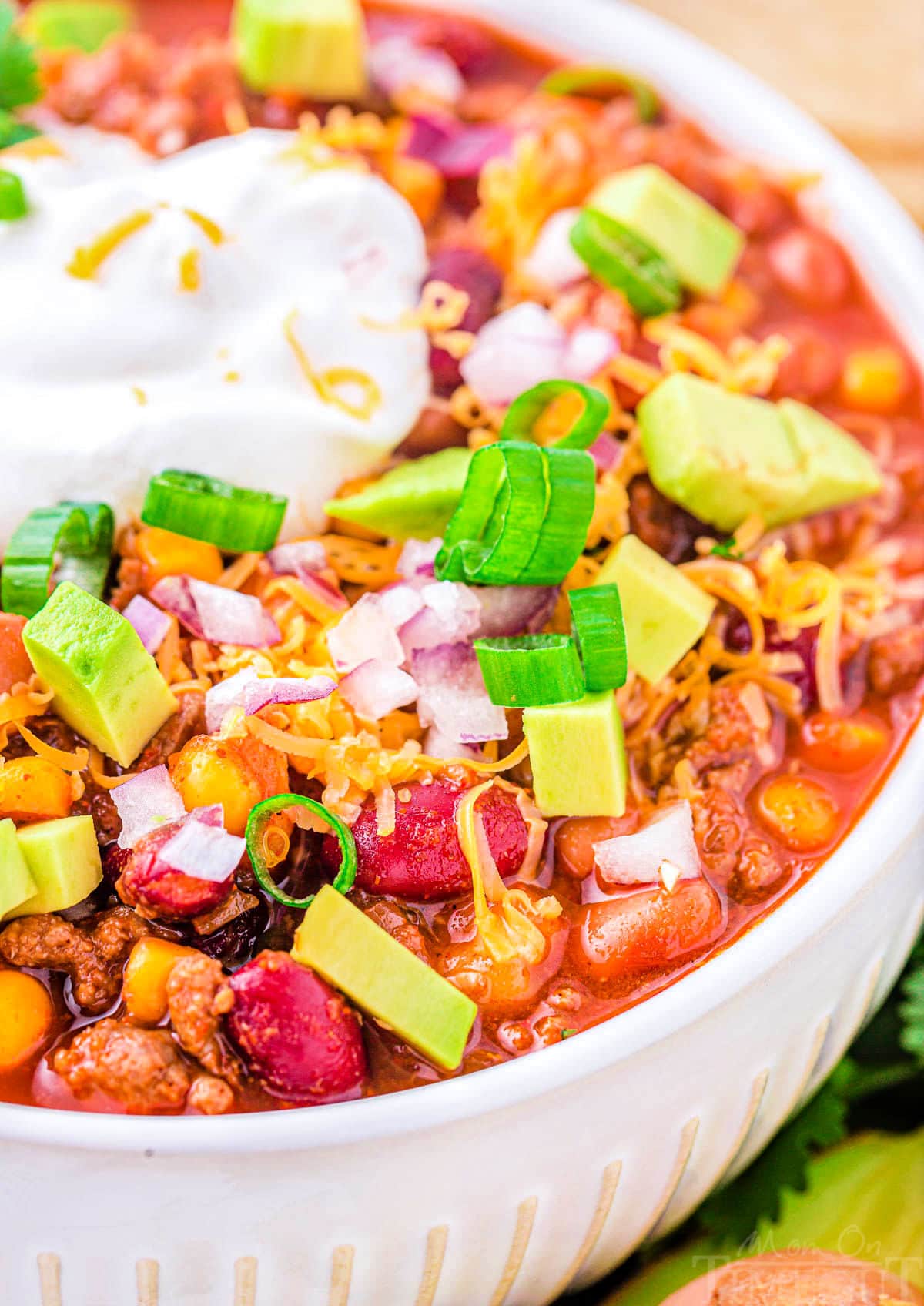 close up look at bowl of taco soup loaded with fresh toppings and sour cream.