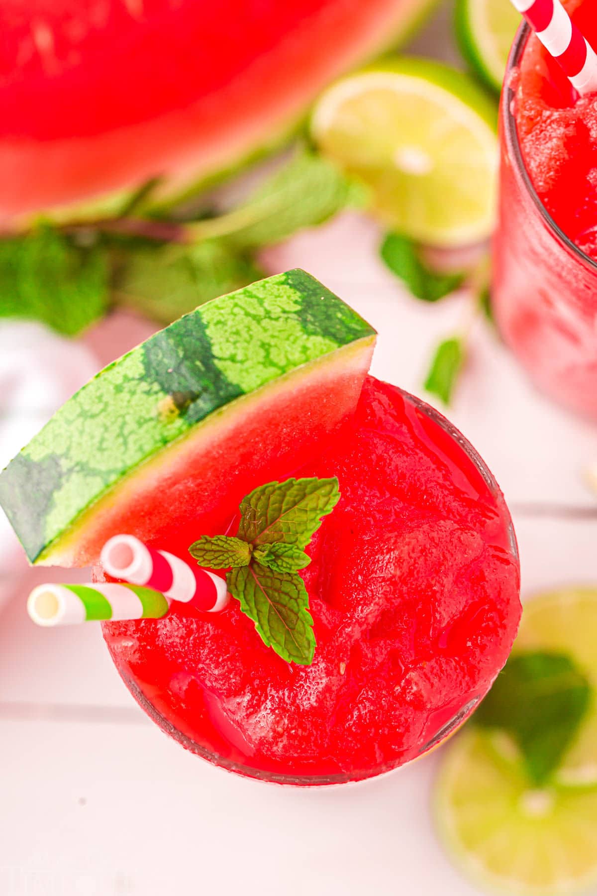 top down look at watermelon slushie in glass with watermelon half next to it.