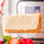 one slice of instant pot cheesecake being held above the rest of the cheesecake in front of an instant pot.