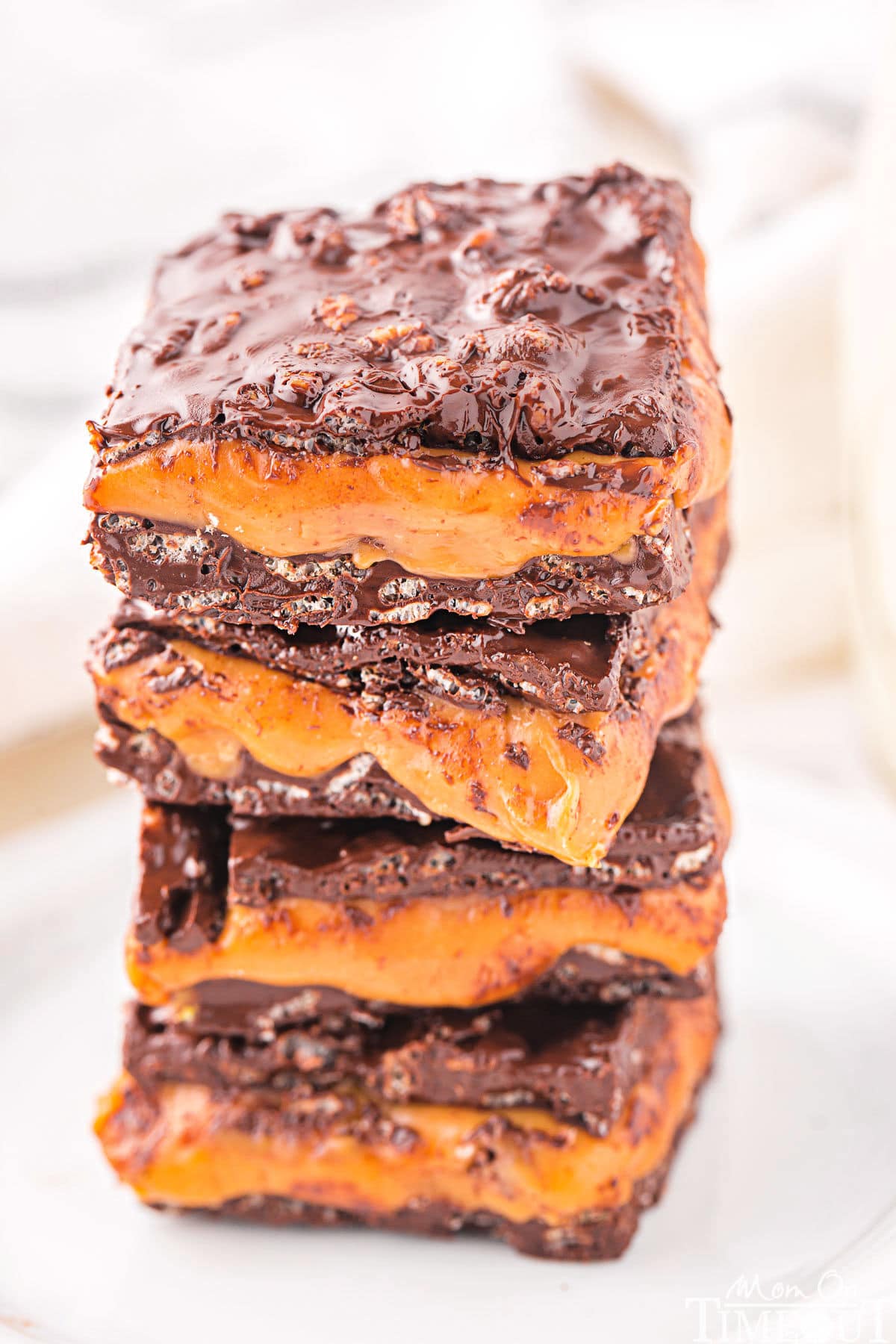 homemade 100 grand bar recipe cut into squares and stacked four high on a white plate.