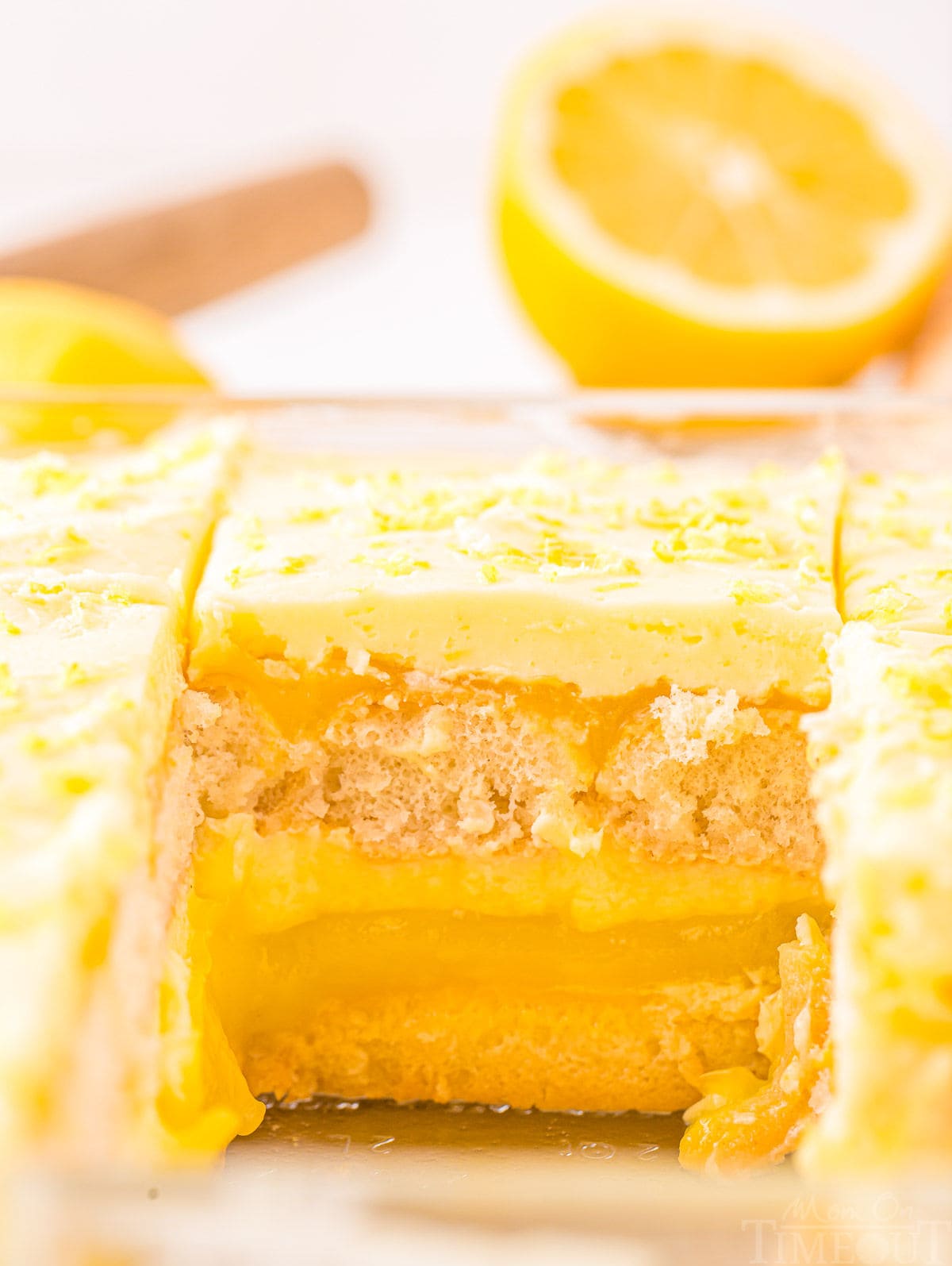 shot of lemon tiramisu in the clear baking dish with one serving removed. can see the clear layers of the dessert.