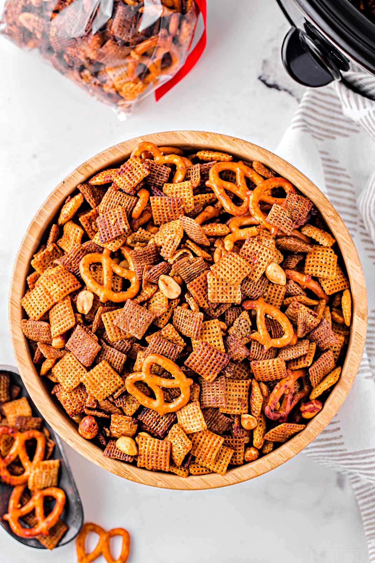 top down view of crockpot chex mix in a large wood bowl.