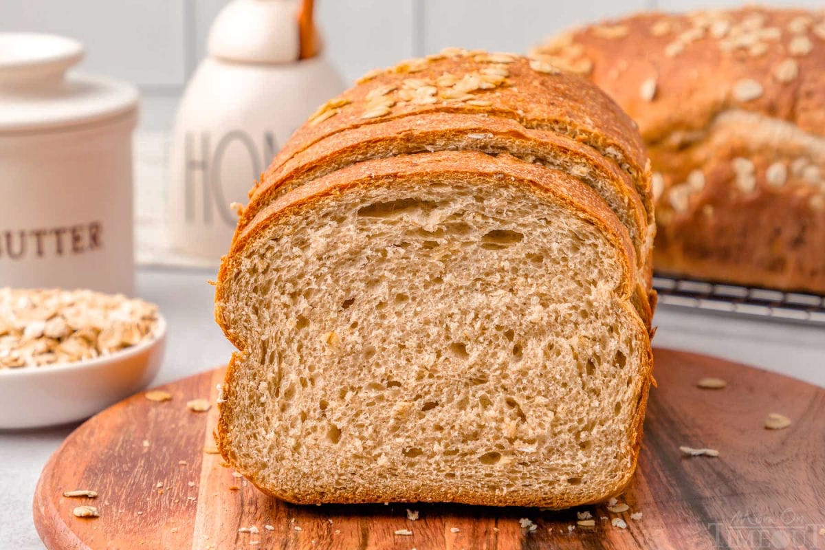 loaf of whole wheat board on a wood board with the end cut off.