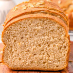 loaf of whole wheat board on a wood board with the end cut off.