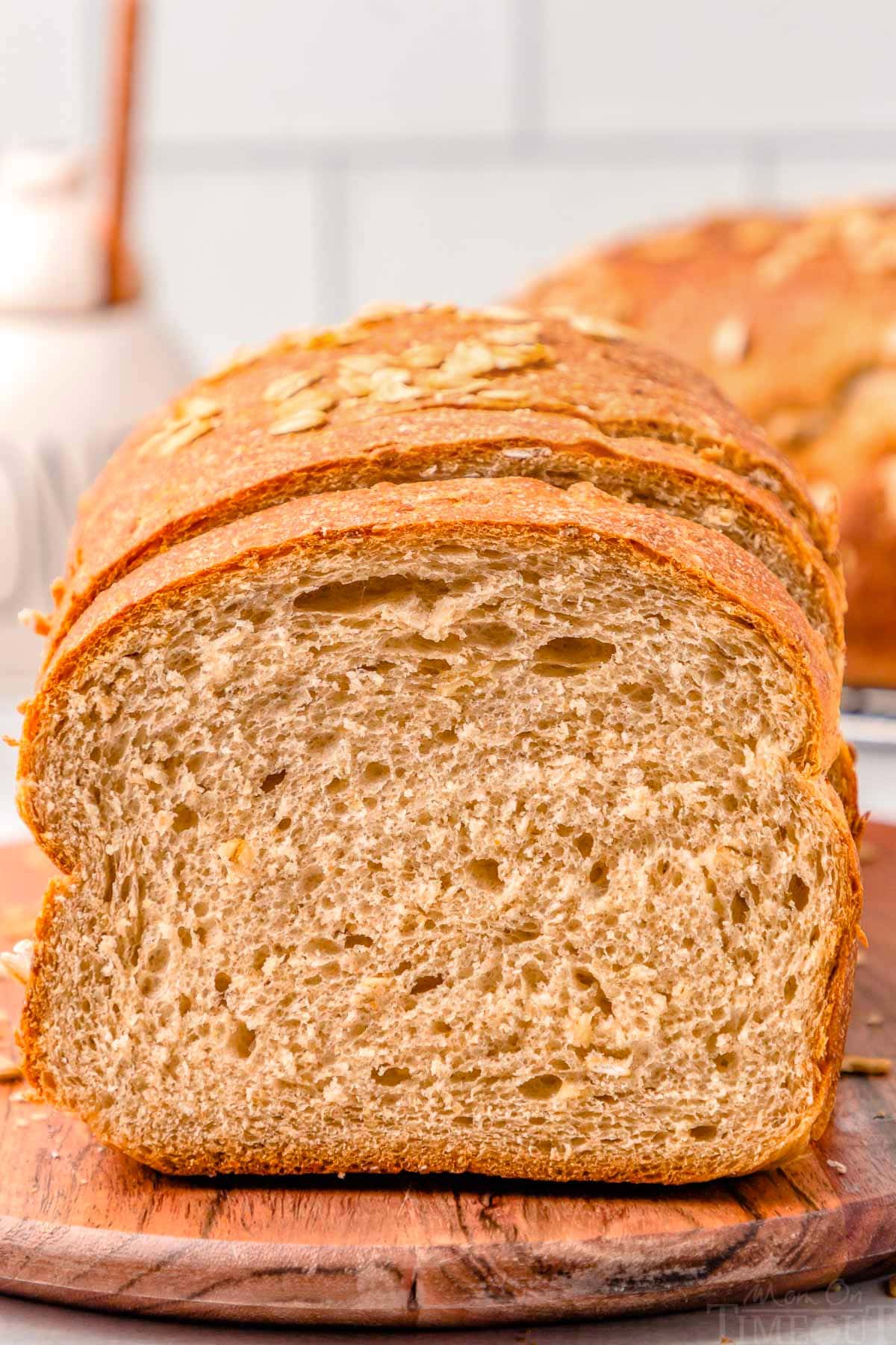 loaf of whole wheat board on a wood board with the end cut off.