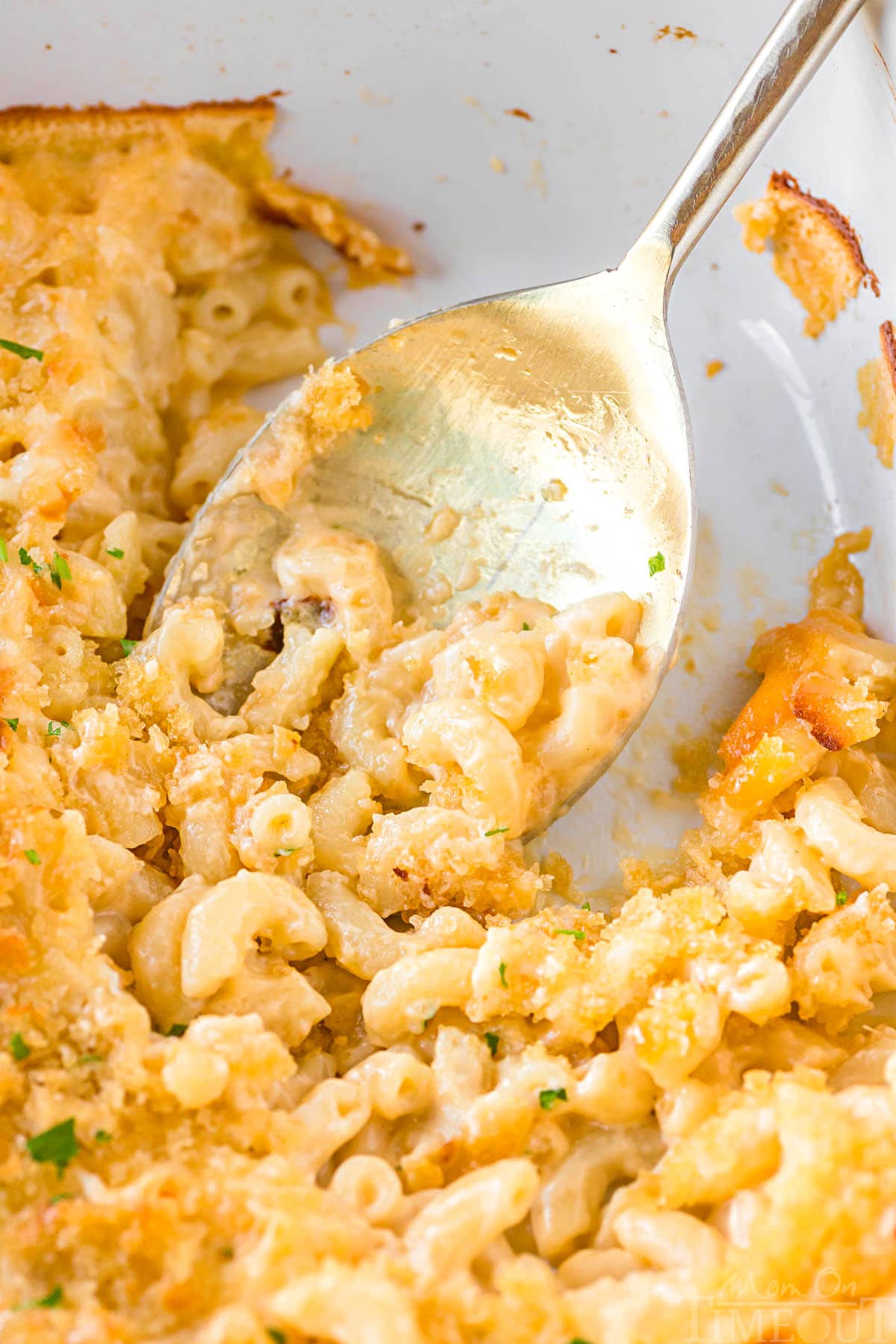 top down view of casserole dish with a serving or two of mac and cheese with velveeta removed from the oven.