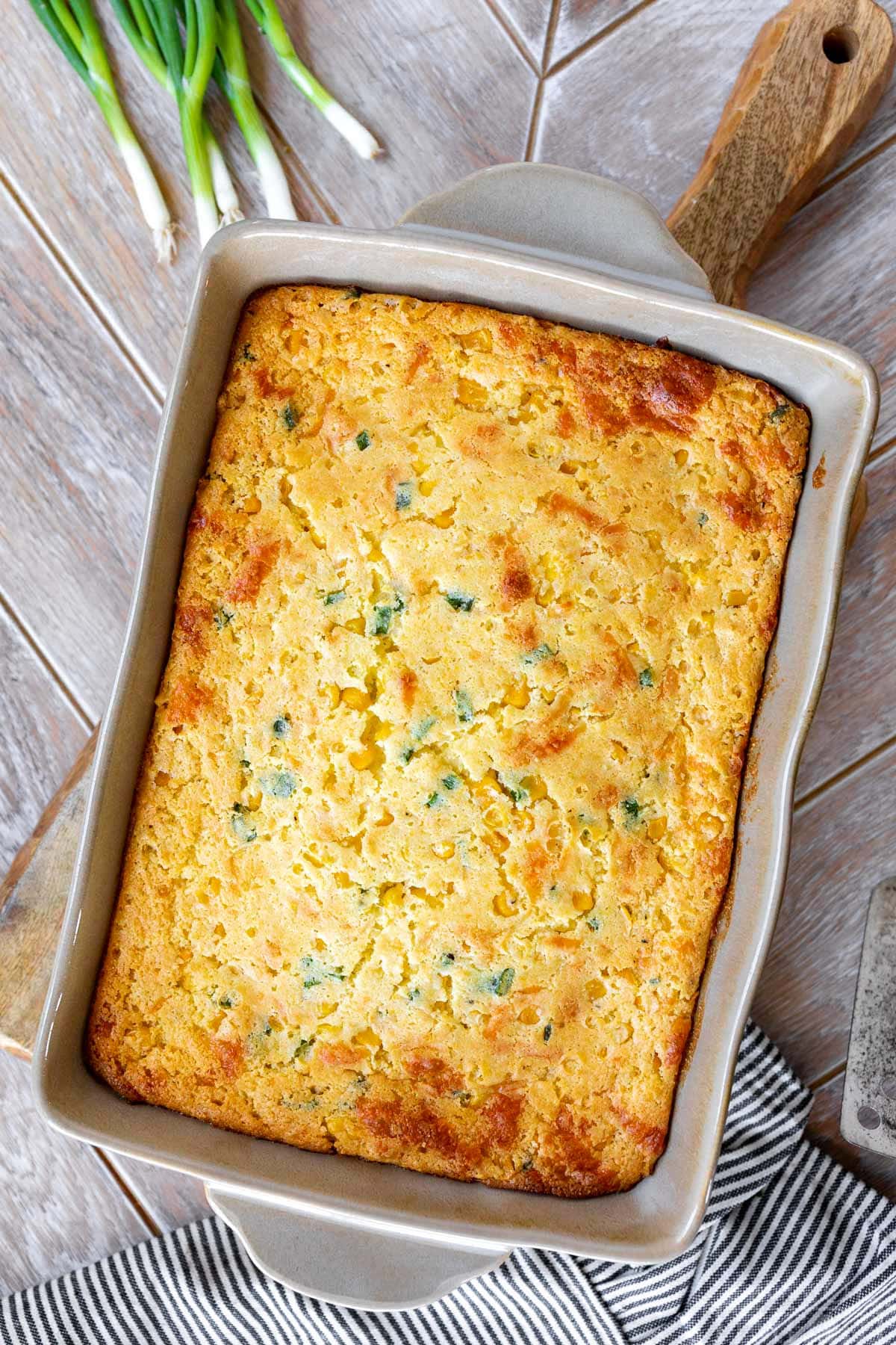 top down view of untouched jiffy corn casserole in light tan casserole dish.