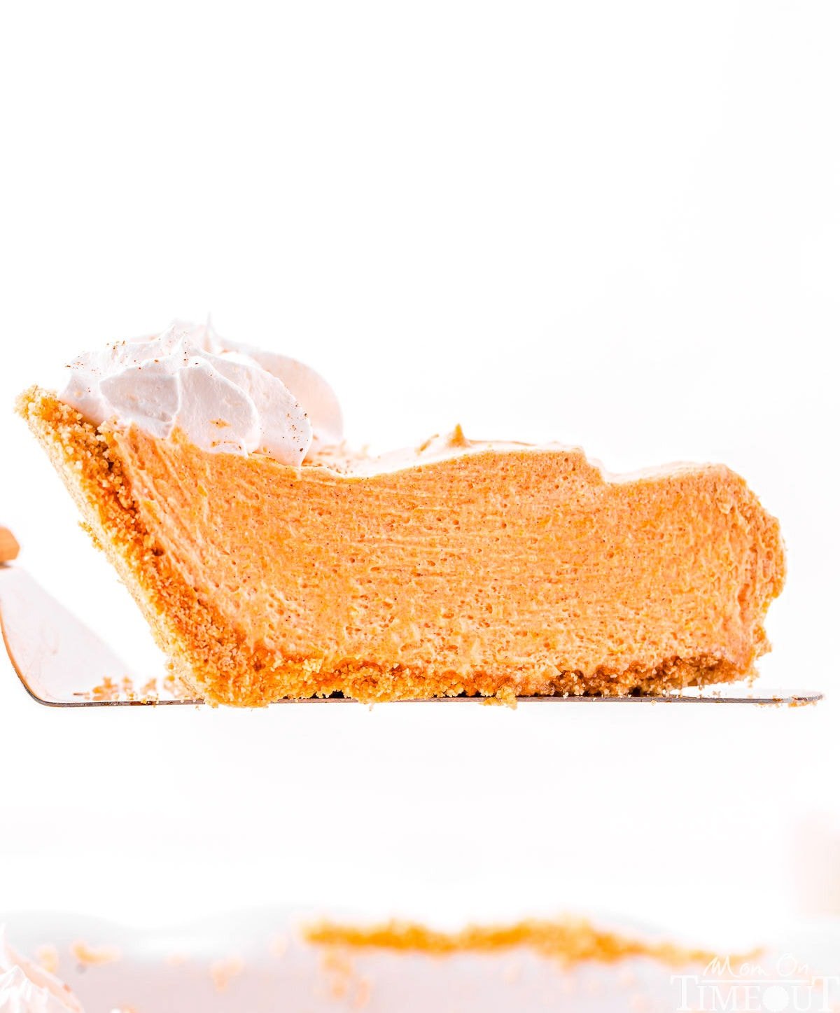 slice of no bake pumpkin pie held above pie plate.