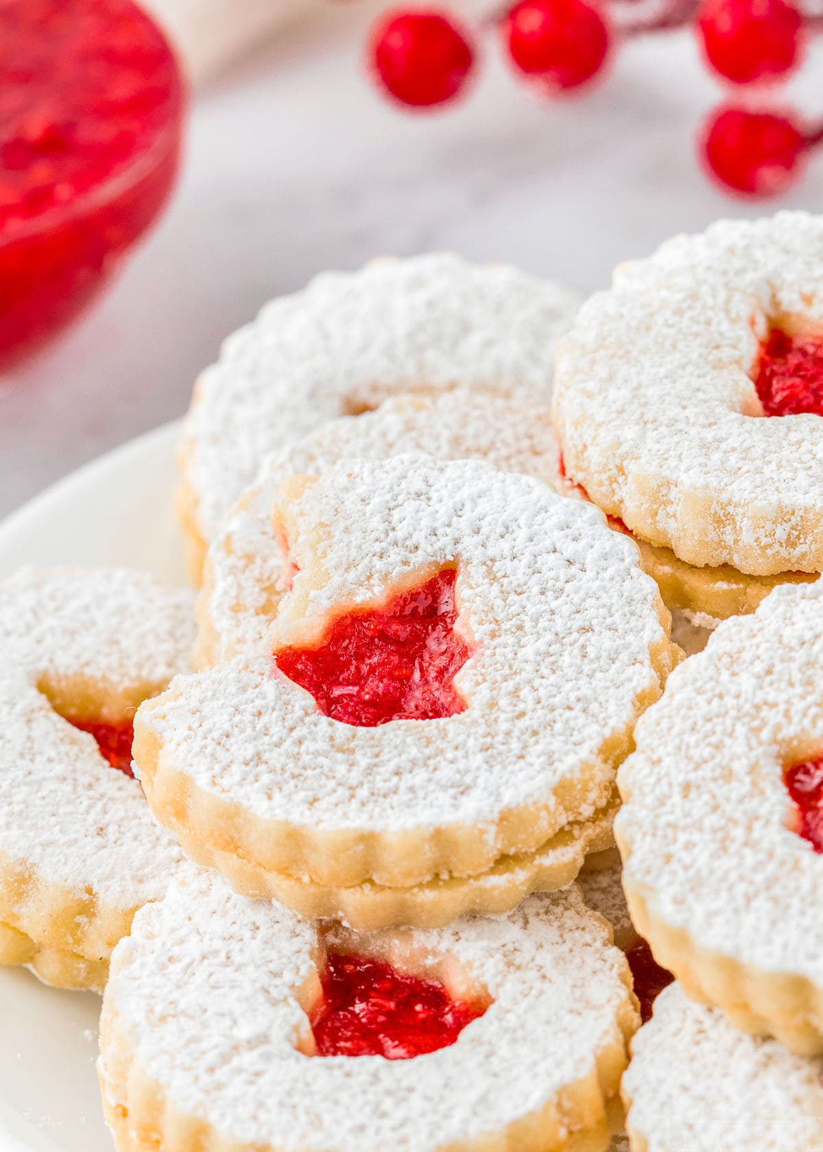 tray of linzer cookies with one having a bite out of it.