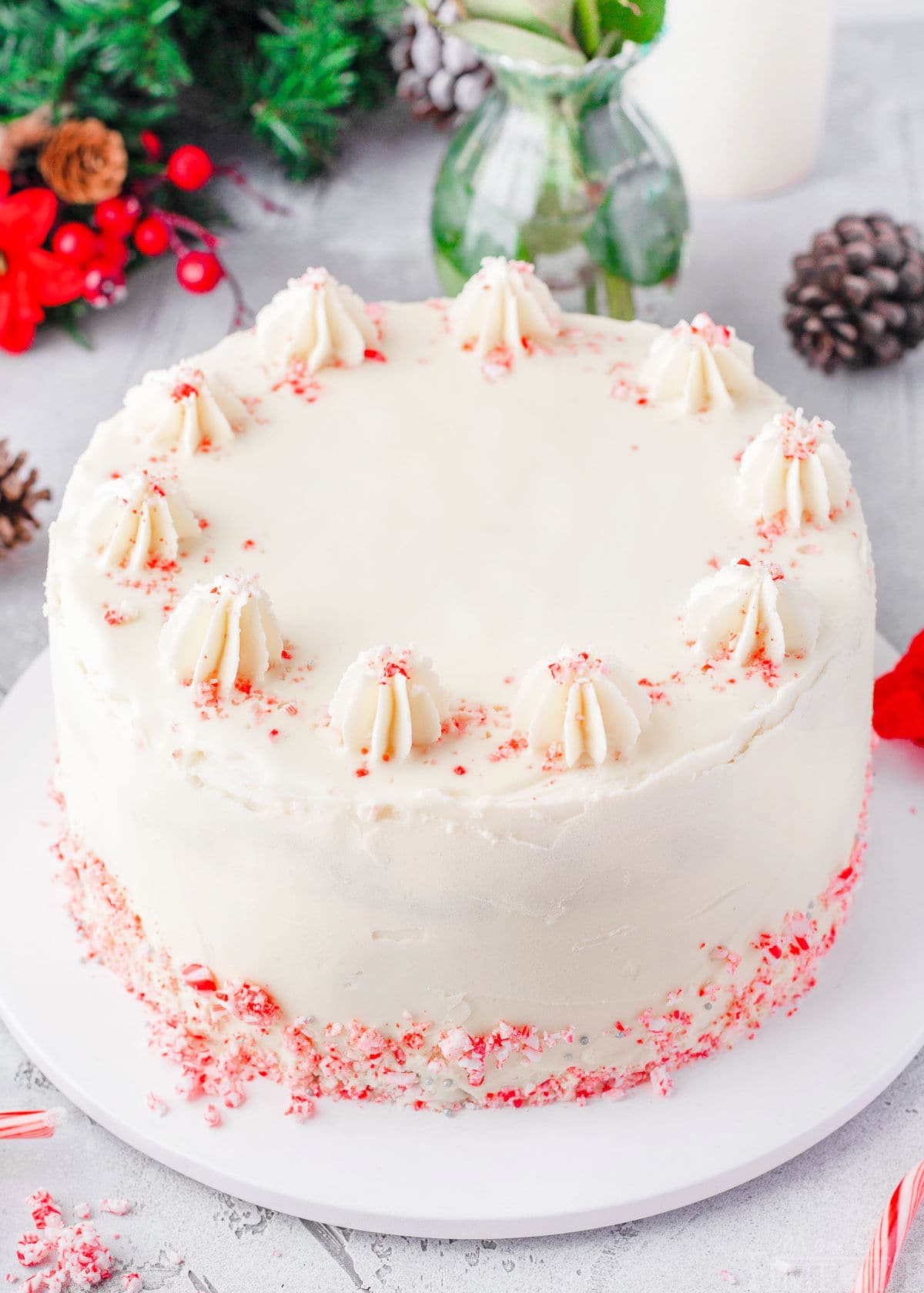 whole peppermint cake frosted with peppermint frosting and candy canes.