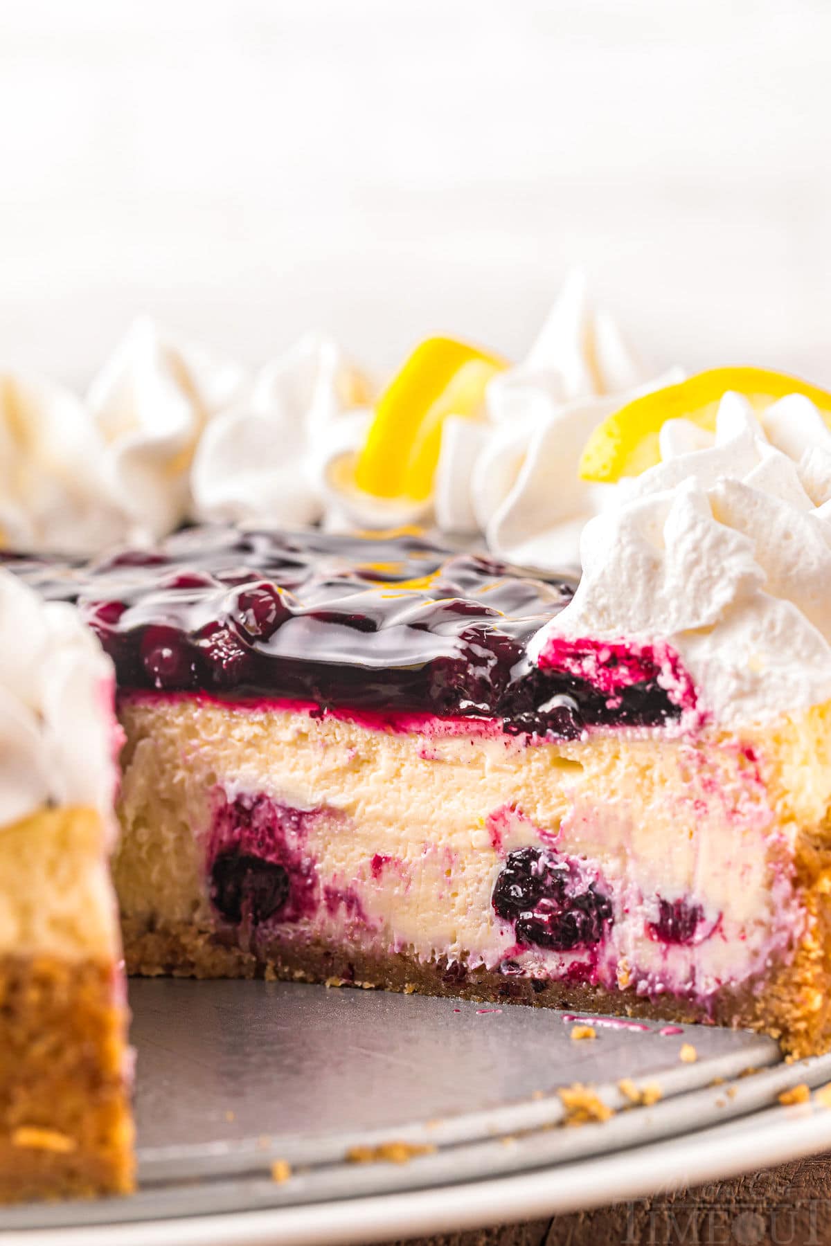 lemon blueberry cheesecake with a piece removed.