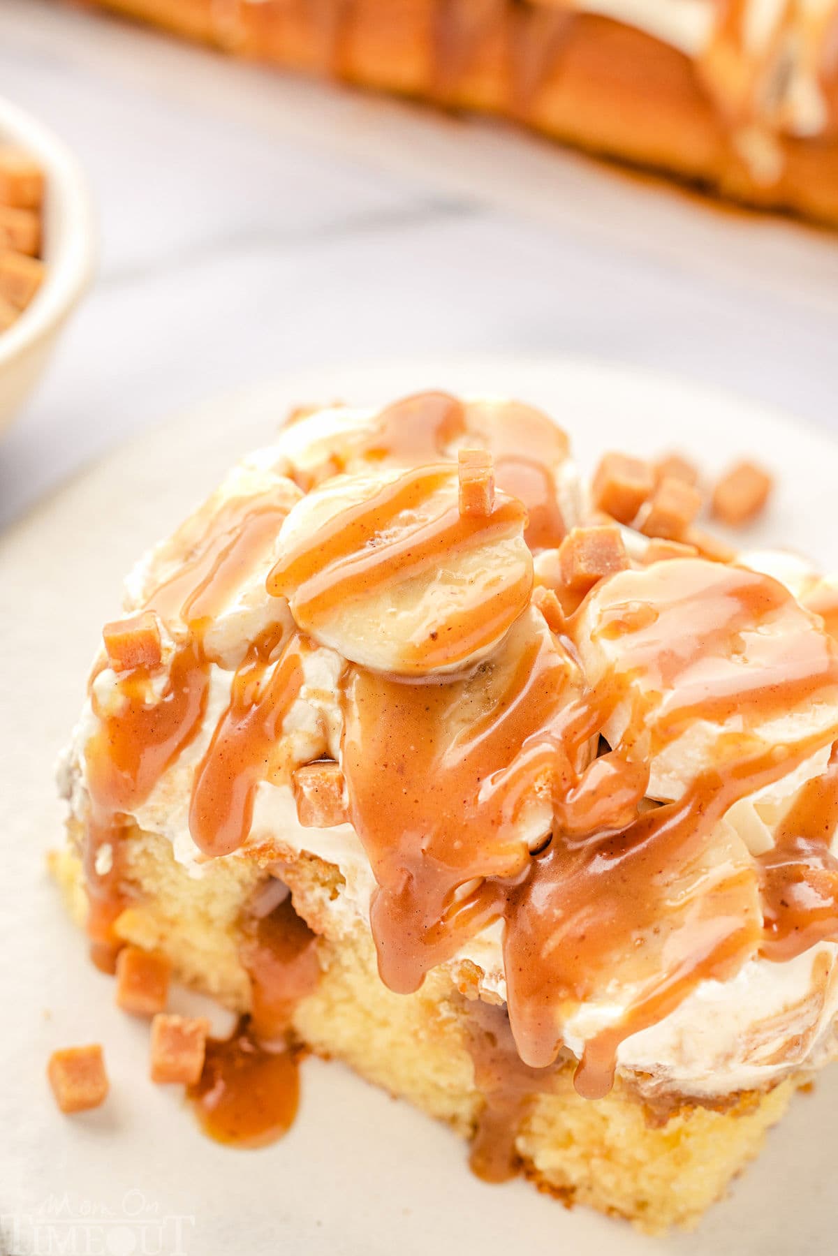 top down angled view of a piece of banoffee cake on a round white plate.