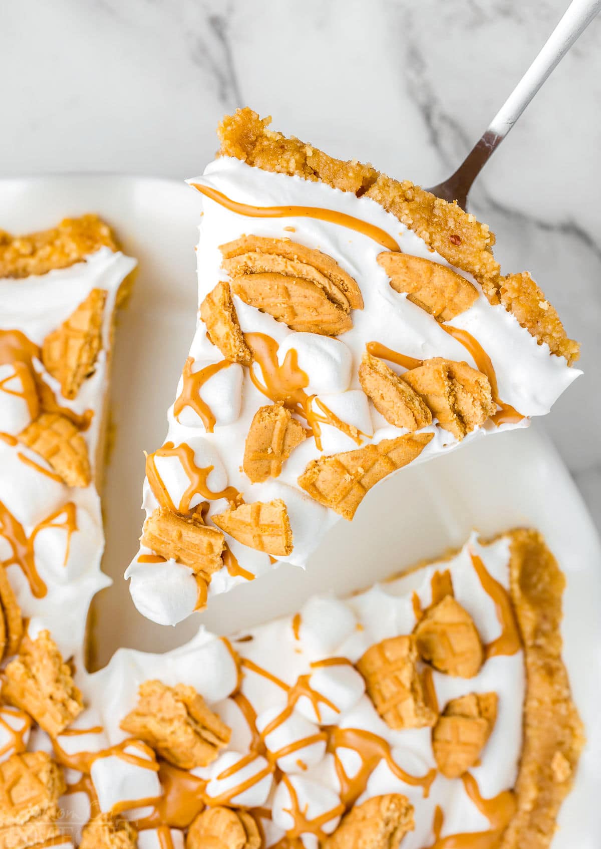 piece of fluffernutter pie being lifted out of the white pie dish.