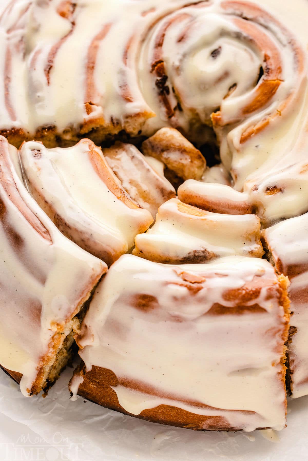 close up, top down look at giant cinnamon roll cake recipe with two slices cut.