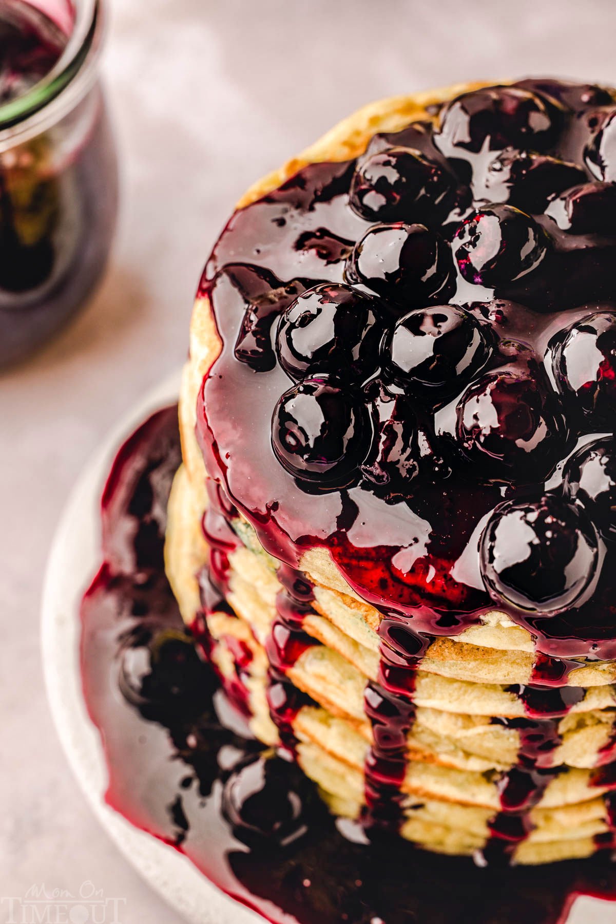 top down view of a stack of lemon ricotta pancakes generously topped with blueberry sauce. 