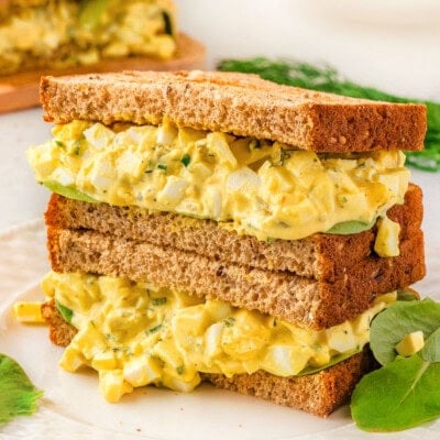 Two egg salad sandwiches stacked on top of each other.