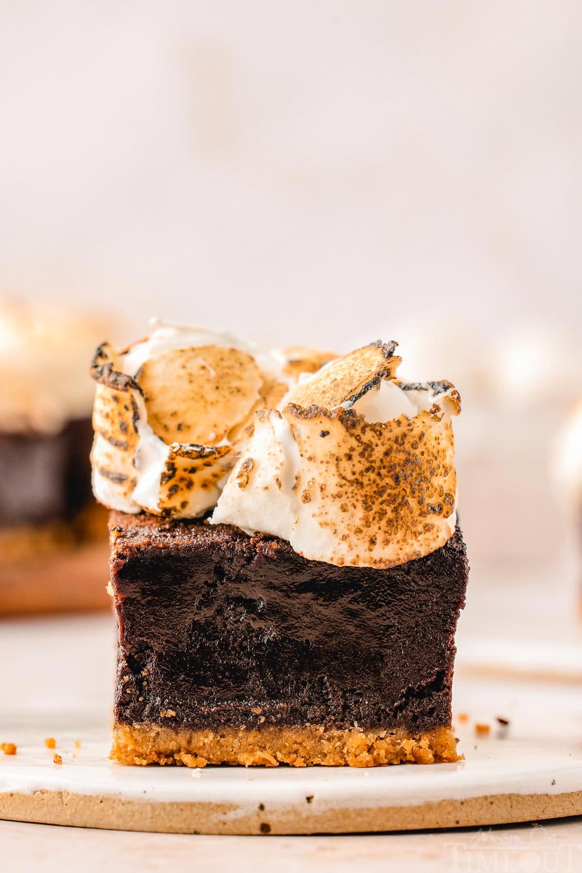 Single s'mores brownies on small white plate ready to be served.
