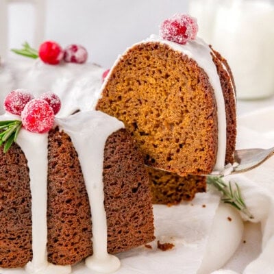 A spatula holding a piece of gingerbread bundt cake above the rest of the cake.
